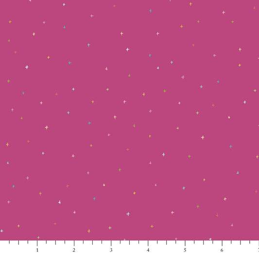 Pink fabric with small colorful star patterns on a pink background